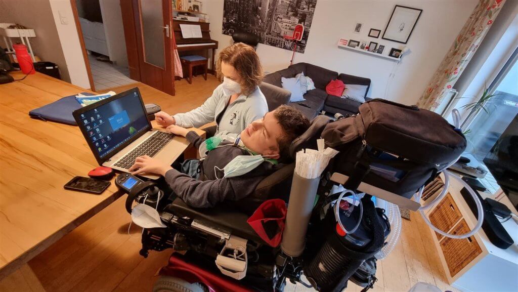 Frau Weinzierl sitzt im Wohnzimmer des Patienten am Schreibtisch.